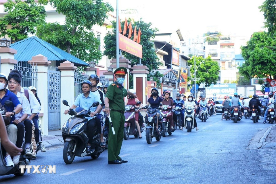 Lực lượng công an phân luồng giao thông trên phố Khương Hạ, quận Thanh Xuân. (Ảnh: Tuấn Anh/TTXVN)