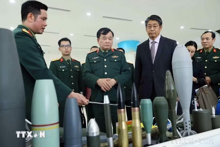 Thượng tướng Hoàng Xuân Chiến, Thứ trưởng Bộ Quốc phòng, Trưởng Cơ quan Thường trực Ban Chỉ đạo Quốc gia khắc phục hậu quả bom mìn và chất độc hóa học sau chiến tranh (Ban Chỉ đạo 701) cùng Đại sứ đặc mệnh toàn quyền Nhật Bản tại Việt Nam Ito Naoki tham quan các mô hình xử lý tín hiệu vật liệu nổ tại lễ công bố Dự án tiếp nhận trang thiết bị rà phá bom mìn do Nhật Bản tài trợ (28/2/2025). (Ảnh: An Đăng/TTXVN)