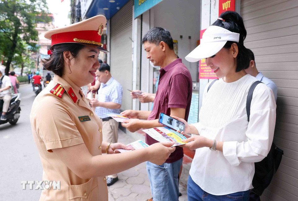 Cán bộ, chiến sỹ Đội Cảnh sát giao thông số 7 phát nước cho người nhà thí sinh tại điểm thi Trường Trung học cơ sở Nguyễn Trãi (quận Thanh Xuân, Hà Nội). (Ảnh: Phạm Kiên/TTXVN)