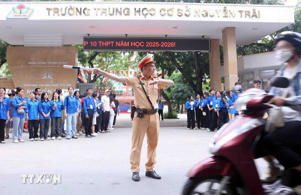 Cán bộ, chiến sỹ Đội Cảnh sát giao thông số 7 điều tiết, phân luồng giao thông tại điểm thi Trường Trung học cơ sở Nguyễn Trãi (quận Thanh Xuân, Hà Nội). (Ảnh: Phạm Kiên/TTXVN)