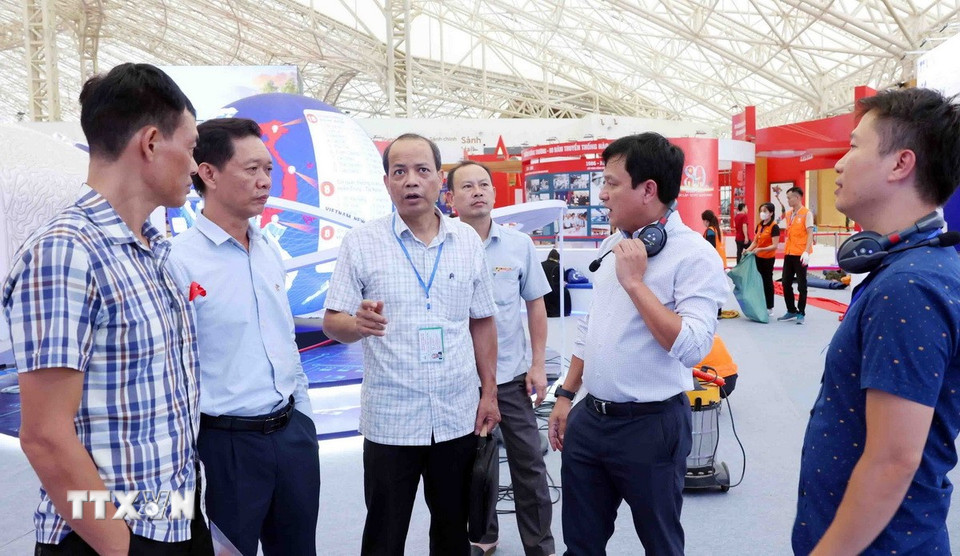 Lãnh đạo các đơn vị chuyên môn của TTXVN trao đổi công tác chuẩn bị tại khu trưng bày. (Ảnh: Phạm Kiên/TTXVN)