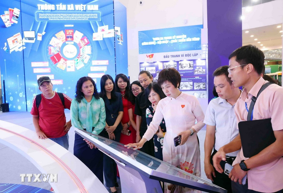 Tổng Giám đốc Vũ Việt Trang trực tiếp chỉ đạo tại khu trưng bày của Thông tấn xã Việt Nam. (Ảnh: Phạm Kiên/TTXVN)