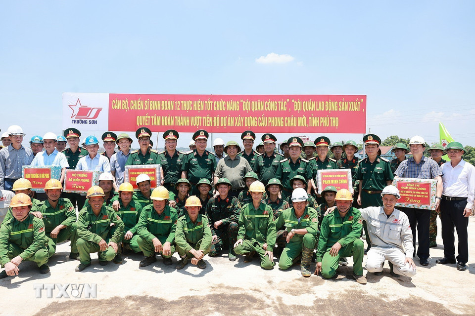 Thủ tướng Phạm Minh Chính tặng quà động viên công nhân thi công cầu Phong Châu mới trên Quốc lộ 32C, tỉnh Phú Thọ. (Ảnh: Dương Giang/TTXVN)