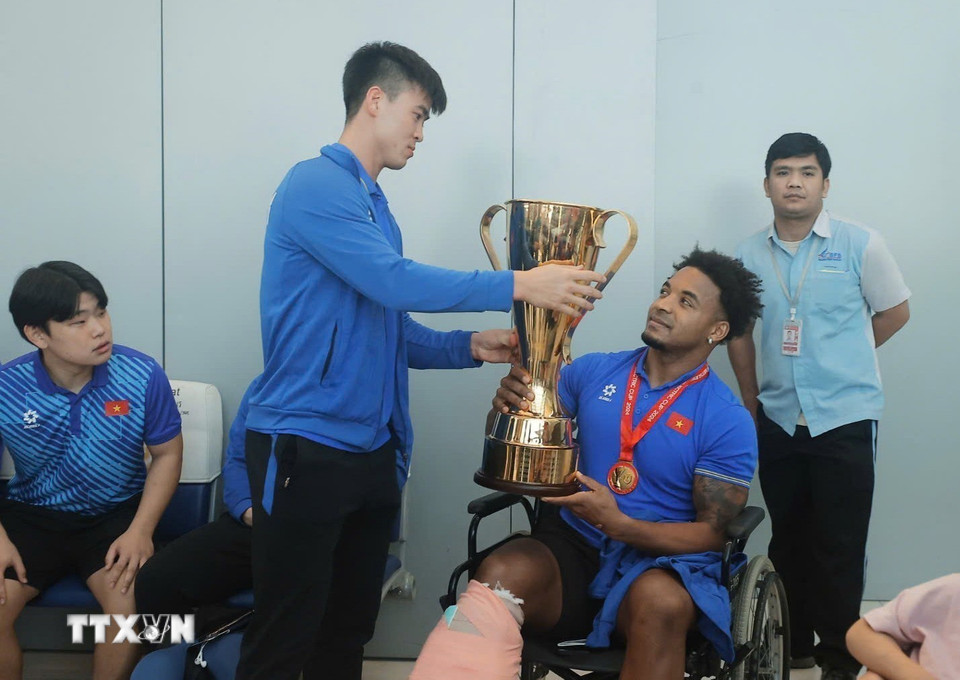 Duy Mạnh trao chiếc cúp vô địch ASEAN Cup 2024 cho Xuân Son tại Sân bay quốc tế Suvarnabhumi (Bangkok) trước giờ khởi hành về nước, trưa 6/1. (Ảnh: Minh Quyết/TTXVN)