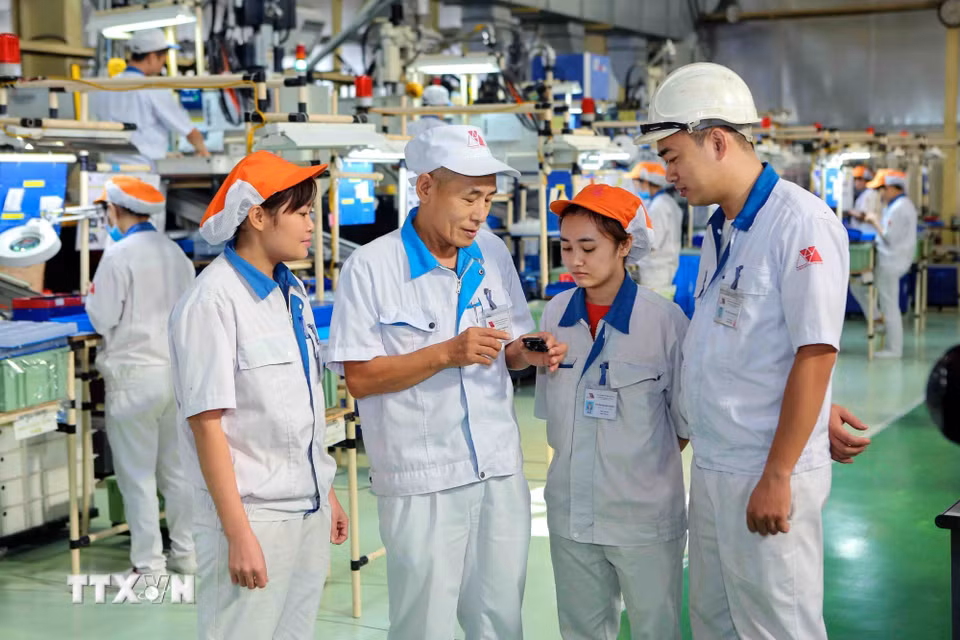 Chuyên gia Nhật Bản trao đổi công việc với công nhân Việt Nam tại Công ty TNHH Yokoi Muold Việt Nam (vốn đầu tư của Nhật Bản) trong khu công nghiệp Đình Trám (Bắc Giang). (Ảnh: Thành Đạt/TTXVN)