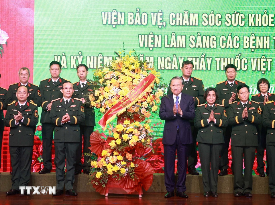 Tổng Bí thư Tô Lâm tặng hoa chúc mừng đội ngũ giáo sư, bác sỹ Bệnh viện Trung ương Quân đội 108. (Ảnh: Thống Nhất/TTXVN)