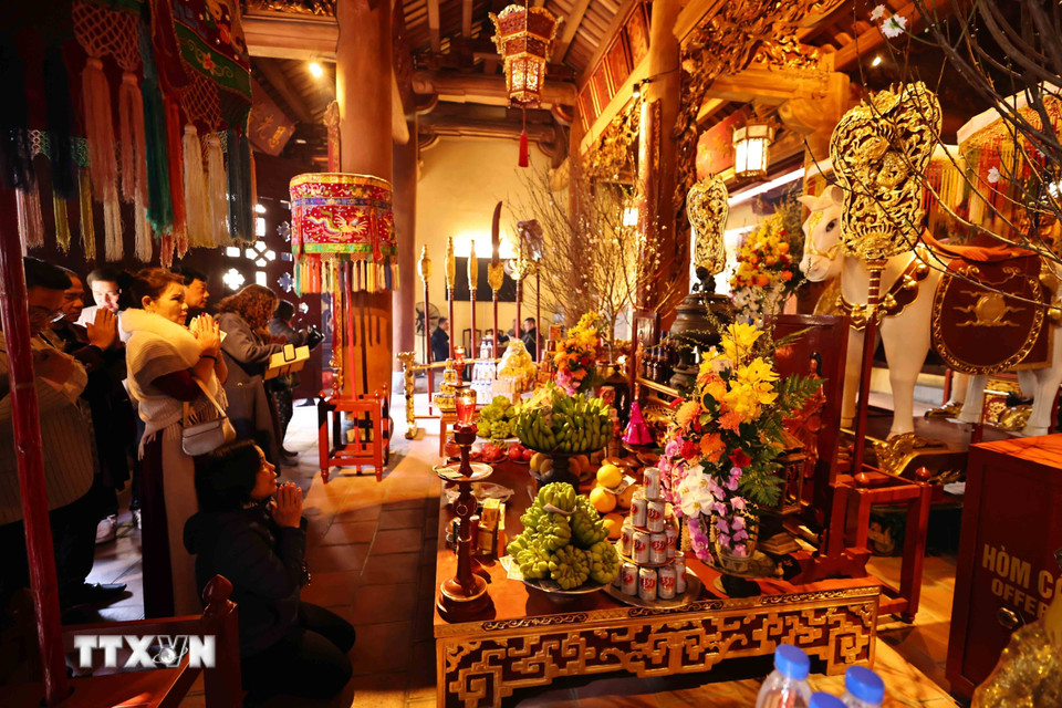 Người dân đi lễ đầu năm tại đền Bạch Mã để cầu mong sức khỏe, bình an cho gia đình. (Ảnh: Minh Đức/TTXVN)