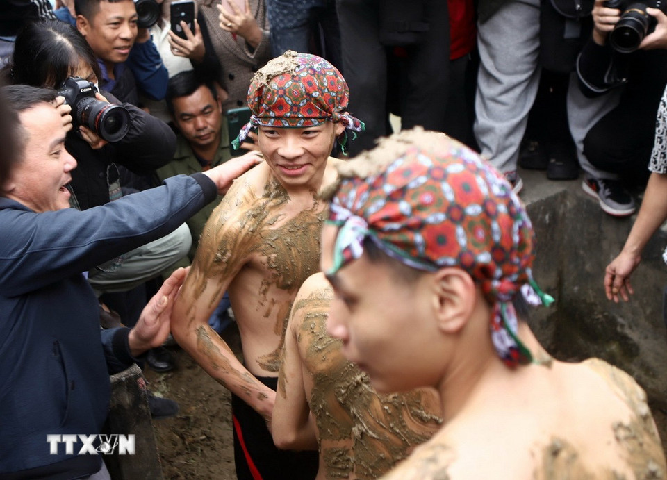 Sau khi tắm, các “Bụt” được rước đi thực hiện nghi thức trát bùn. (Ảnh: Hoàng Hùng/TTXVN)