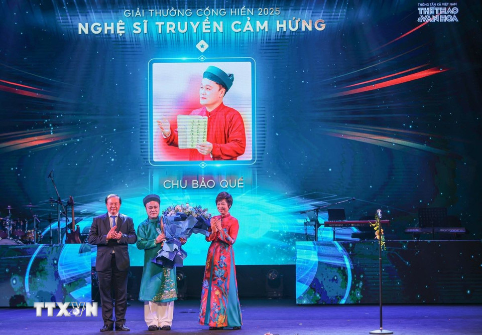 Thứ trưởng Bộ Văn hóa, Thể thao và Du lịch Tạ Quang Đông và Tổng Giám đốc TTXVN Vũ Việt Trang trao giải "Nghệ sỹ truyền cảm hứng" cho nghệ sỹ Chu Bảo Quế. (Ảnh: Hoàng Hiếu/TTXVN)