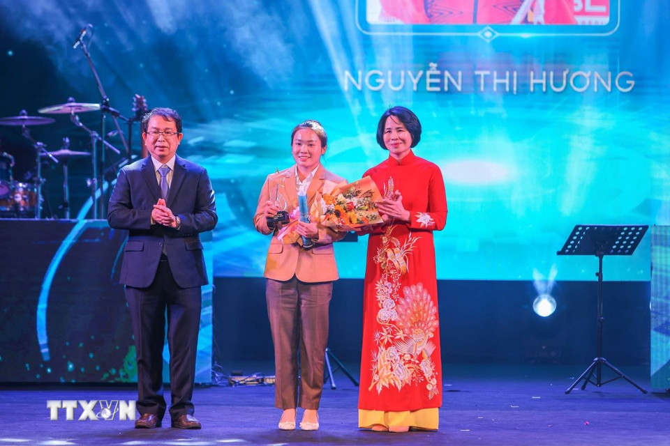 Phó Tổng Giám đốc TTXVN Nguyễn Tuấn Hùng và Phó Cục trưởng Cục Thể thao Lê Thị Hoàng Yến trao giải “Gương mặt trẻ thể thao của năm” cho vận động viên đua thuyền Canoeing Nguyễn Thị Hương. (Ảnh: Hoàng Hiếu/TTXVN)