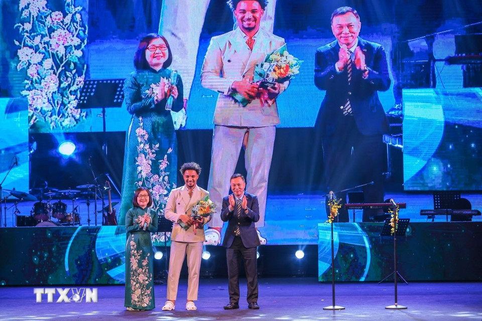 Phó Tổng Giám đốc TTXVN Đoàn Thị Tuyết Nhung và Chủ tịch Liên đoàn Bóng đá Việt Nam Trần Quốc Tuấn trao thưởng hạng mục “Gương mặt thể thao của năm” cho cầu thủ bóng đá Nguyễn Xuân Son. (Ảnh: Hoàng Hiếu/TTXVN)