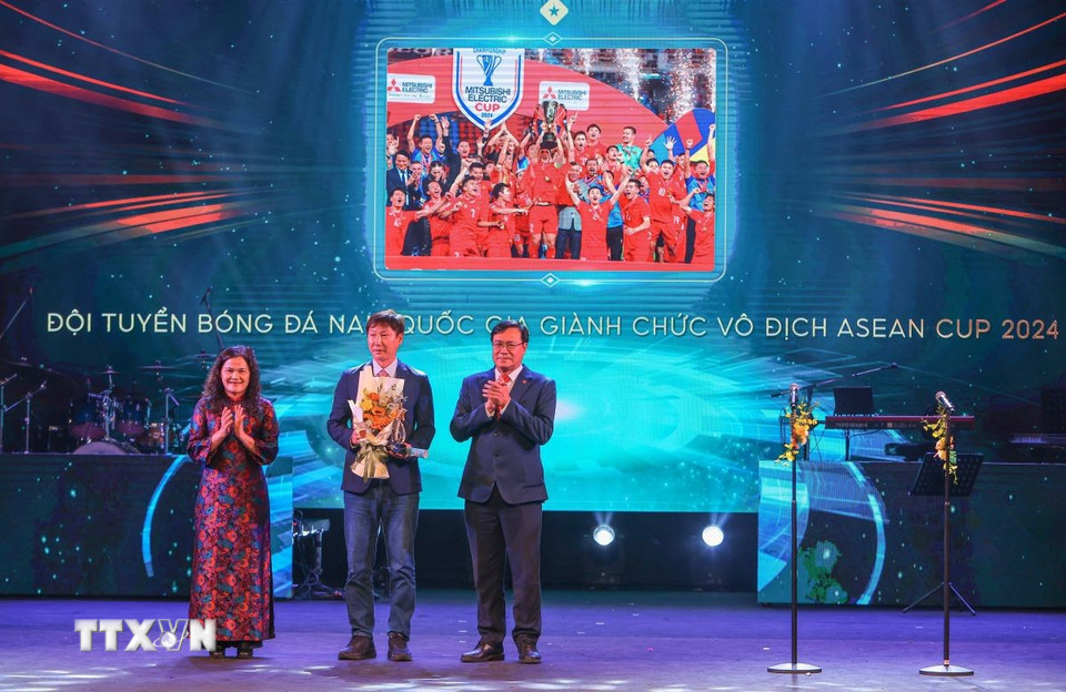 Phó Tổng Giám đốc TTXVN Nguyễn Thị Sự và Cục trưởng Cục Thể thao Đặng Hà Việt trao “Chiến tích thể thao của năm” cho huấn luyện viên Kim Sang Sik - đại diện Đội tuyển Bóng đá nam Việt Nam. (Ảnh: Hoàng Hiếu/TTXVN)