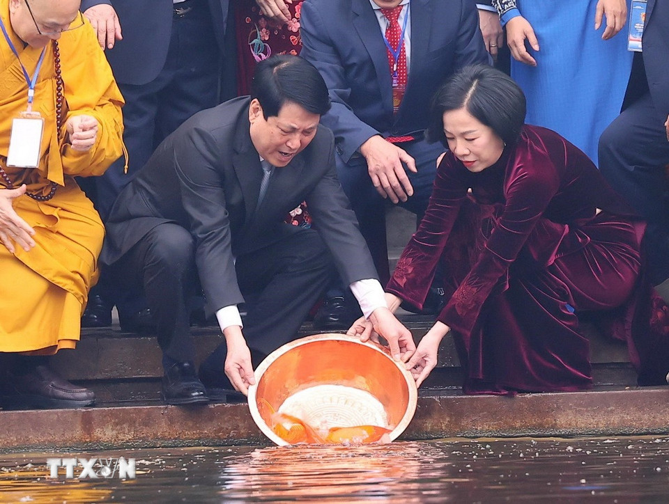 Chủ tịch nước Lương Cường và Phu nhân thả cá chép tiễn ông Công, ông Táo tại Ao cá Bác Hồ trong Khu Di tích Phủ Chủ tịch. (Ảnh: Văn Điệp/TTXVN)