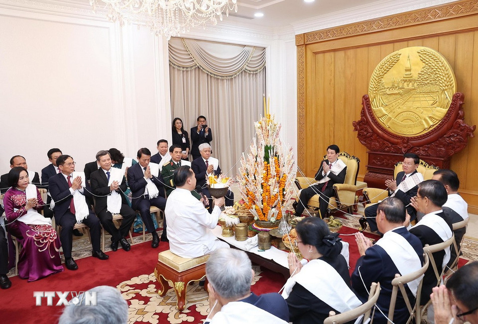 Chủ tịch nước Lương Cường cùng Tổng Bí thư, Chủ tịch nước Lào Thongloun Sisoulith dự lễ buộc chỉ cầu bình an, may mắn nhân dịp Tết Bunpimay của Lào. (Ảnh: Lâm Khánh/TTXVN)