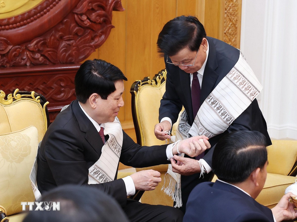 Tổng Bí thư, Chủ tịch nước Lào Thongloun Sisoulith buộc chỉ cho Chủ tịch nước Lương Cường. (Ảnh: Lâm Khánh/TTXVN)