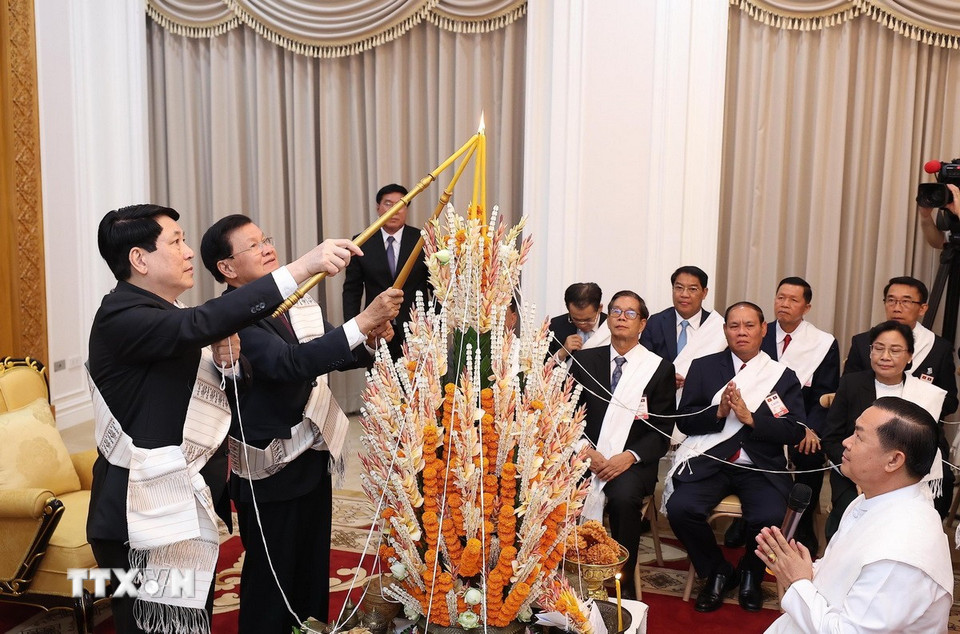Chủ tịch nước Lương Cường cùng Tổng Bí thư, Chủ tịch nước Lào Thongloun Sisoulith dự lễ buộc chỉ cầu bình an, may mắn nhân dịp Tết Bunpimay của Lào. (Ảnh: Lâm Khánh/TTXVN)
