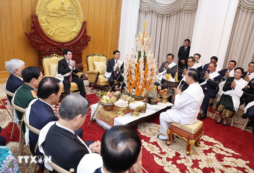 Chủ tịch nước Lương Cường cùng Tổng Bí thư, Chủ tịch nước Lào Thongloun Sisoulith dự lễ buộc chỉ cầu bình an, may mắn nhân dịp Tết Bunpimay của Lào. (Ảnh: Lâm Khánh/TTXVN)