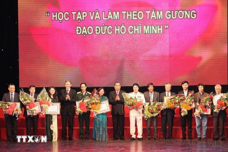 Thường trực Ban Bí thư Lê Hồng Anh và Trưởng Ban Tuyên giáo Trung ương Đinh Thế Huynh trao giải cho các tác giả đoạt giải A tại Lễ trao giải sáng tác, quảng bá tác phẩm văn học, nghệ thuật, báo chí về chủ đề “Học tập và làm việc theo tấm gương đạo đức Hồ Chí Minh” đợt 1 (2011-2013). (Ảnh: Lâm Khánh/TTXVN)