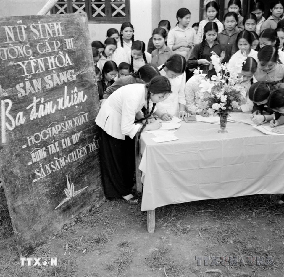 Ở miền Bắc, công tác tuyên giáo tập trung tuyên truyền, đẩy mạnh các phong trào thi đua yêu nước, như “Vì miền Nam ruột thịt”, “Thanh niên ba sẵn sàng," “Phụ nữ ba đảm đang," chi viện đắc lực sức người, sức của cho tiền tuyến lớn miền Nam. Trong ảnh: Đăng ký tham gia Phong trào Ba đảm nhiệm (sau chuyển thành phong trào “Phụ nữ ba đảm đang”) tại Trường cấp III Yên Hòa, Hà Nội. (Ảnh: Thanh Tụng/TTXVN)
