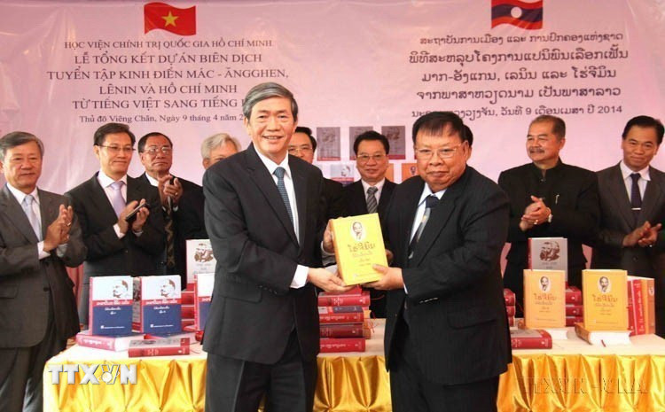 Trưởng Ban Tuyên giáo Trung ương Đinh Thế Huynh trao Tuyển tập "Mác-Ăngghen-Lê Nin và Tư tưởng Hồ Chí Minh" được biên dịch từ tiếng Việt ra tiếng Lào cho Phó Chủ tịch nước Lào Bounnhang Volachith (Vientiane, 9/4/2014). (Ảnh: Hoàng Chương/TTXVN)