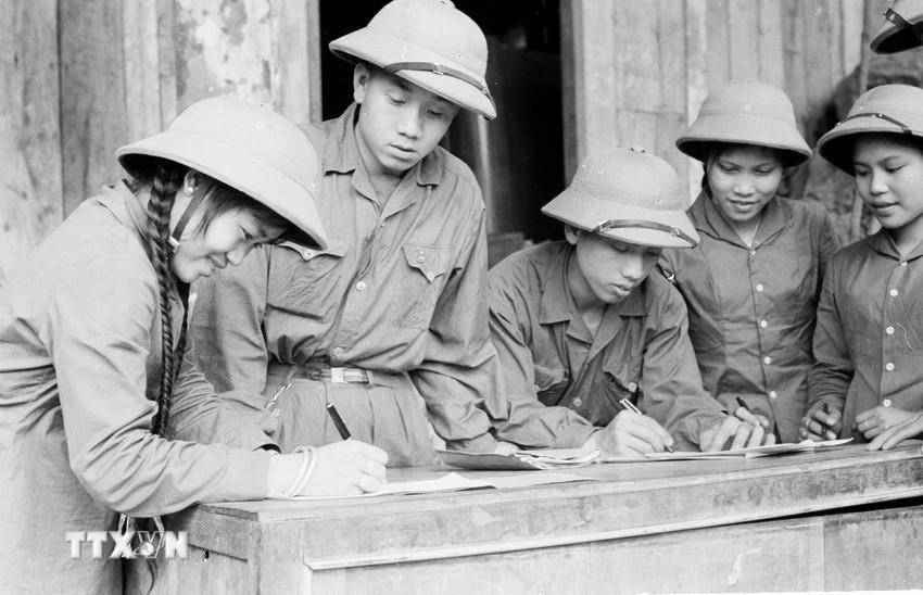 Giai đoạn 1961–1965, công tác tuyên giáo tập trung tuyên truyền, vận động, đẩy mạnh các phong trào thi đua yêu nước, phấn đấu hoàn thành vượt mức kế hoạch 5 năm lần thứ nhất. Nhiều điển hình xuất sắc xuất hiện trong phong trào quần chúng đã trở thành ngọn cờ cổ vũ phong trào thi đua. Trong ảnh: Thanh niên xung phong chống Mỹ, cứu nước Đội 32 ký Quyết tâm thư. (Ảnh: Đức Liên/TTXVN)