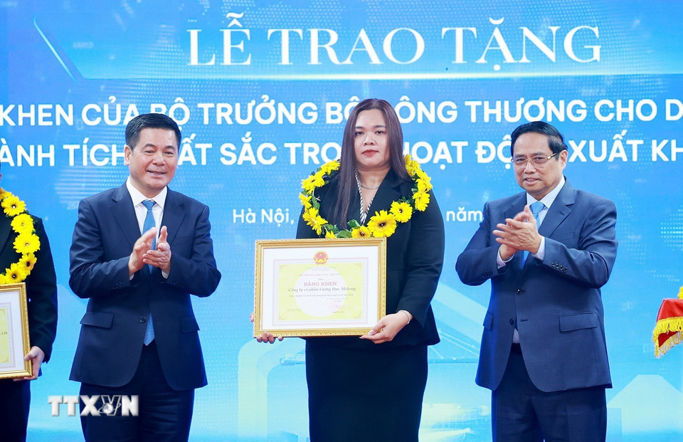 Thủ tướng Phạm Minh Chính và Bộ trưởng Bộ Công Thương Nguyễn Hồng Diên trao hoa và khen thưởng cho các doanh nghiệp có thành tích xuất sắc. (Ảnh: Dương Giang/TTXVN)