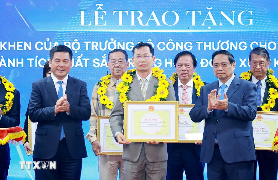Thủ tướng Phạm Minh Chính và Bộ trưởng Bộ Công Thương Nguyễn Hồng Diên trao hoa và khen thưởng cho các doanh nghiệp có thành tích xuất sắc. (Ảnh: Dương Giang/TTXVN)