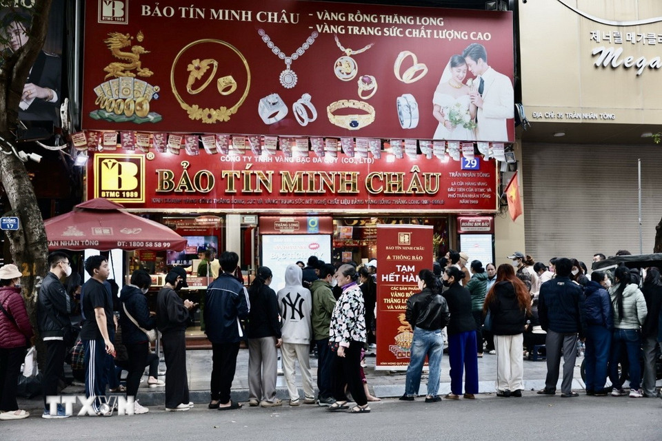 Người dân xếp hàng dài chờ mua vàng tại cửa hàng Bảo Tín Minh Châu trên phố Trần Nhân Tông, Hà Nội, dù có thông báo tạm hết hàng. (Ảnh: Trần Việt/TTXVN)