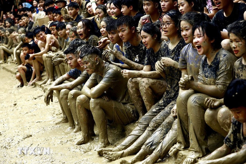 Du khách đến dự hội thường bị lấm lem quần áo nhưng họ vẫn tươi cười bởi điều đó được coi là may mắn. (Ảnh: Thành Đạt/TTXVN)