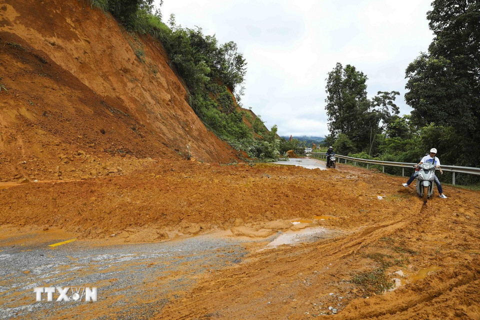 Sạt lở taluy dương khiến đất đá tràn ra mặt đường. (Ảnh: TTXVN)