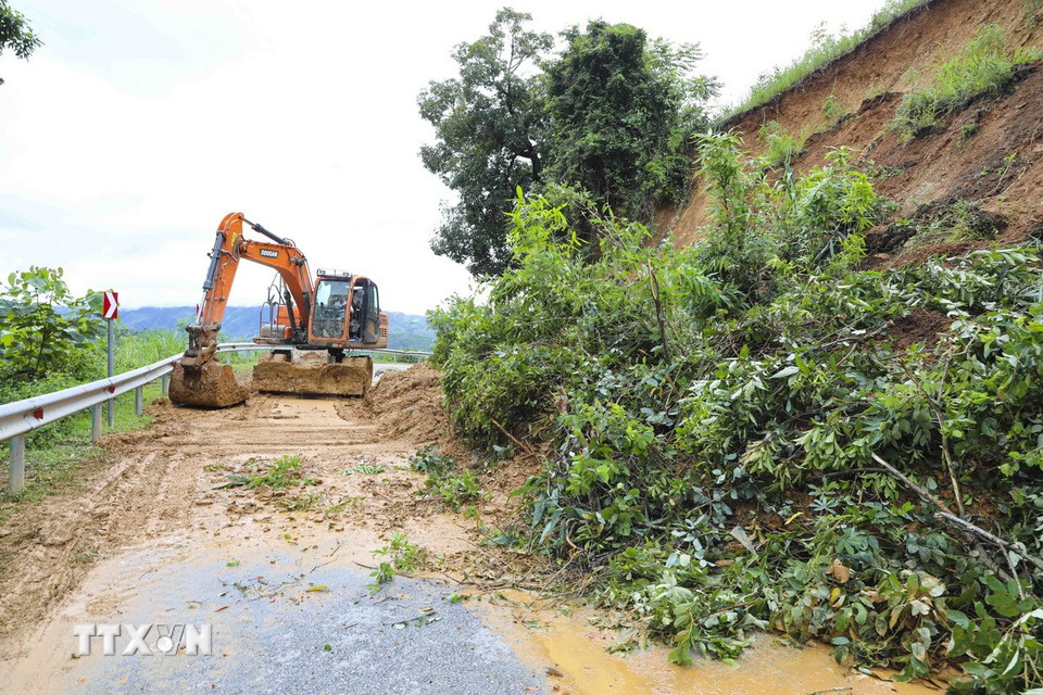Đơn vị thi công tiến hành san gạt các điểm sạt lở trên Quốc lộ 12. (Ảnh: TTXVN)