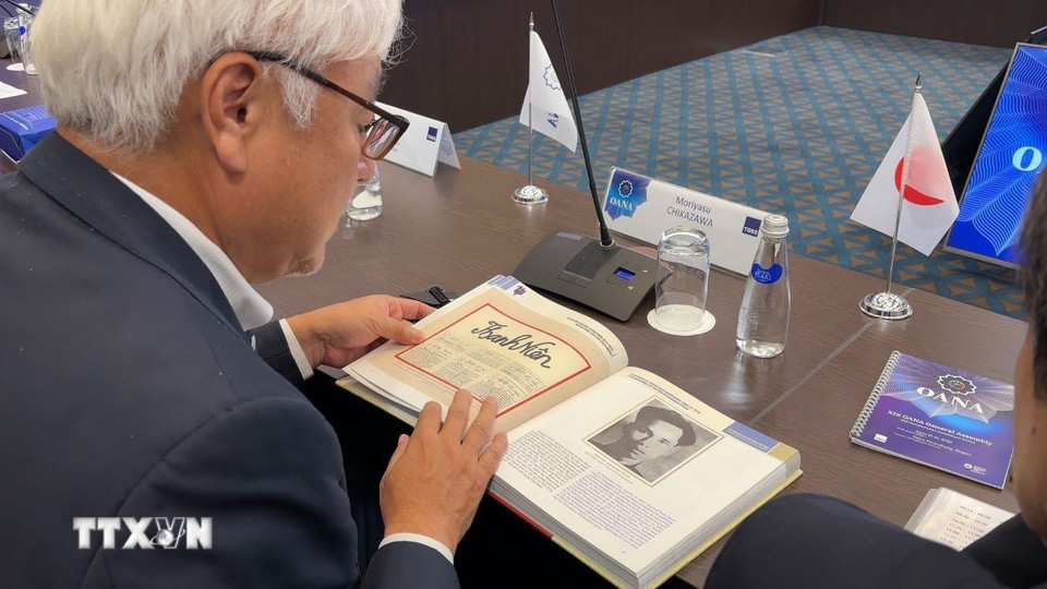 Lãnh đạo các hãng thông tấn thành viên OANA chăm chú xem sách ảnh '100 năm Báo chí Cách mạng Việt Nam' do Nhà xuất bản Thông tấn biên soạn và phát hành. (Ảnh: Tâm Hằng/TTXVN)