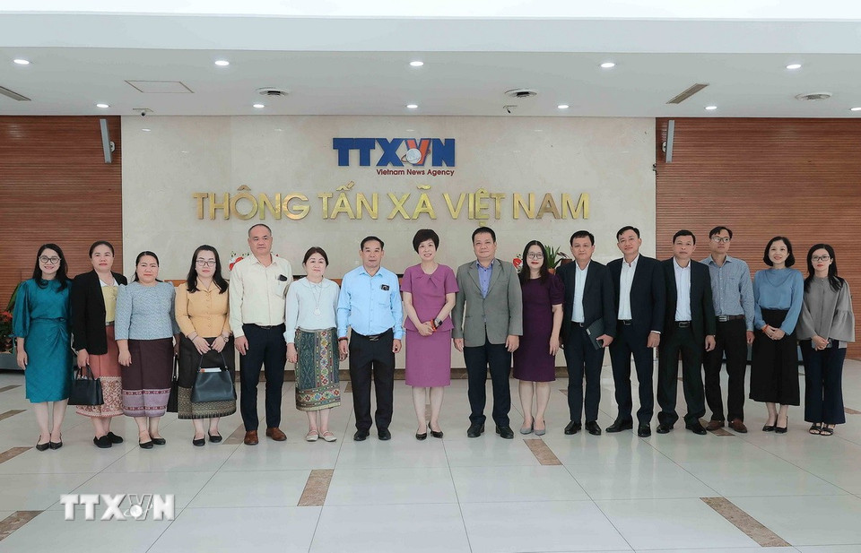 Các đại biểu chụp ảnh lưu niệm tại Trung tâm Thông tấn Quốc gia (số 5 Lý Thường Kiệt, Hà Nội). (Ảnh: An Đăng/TTXVN)