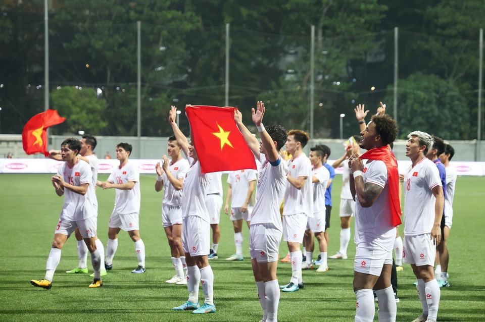 Các cầu thủ chia vui cùng cổ động viên Việt Nam sau trận thắng Singapore 2-0 ở bán kết lượt đi trên sân vận động Jalan Besar (Singapore). (Ảnh: Lê Dương/TTXVN)