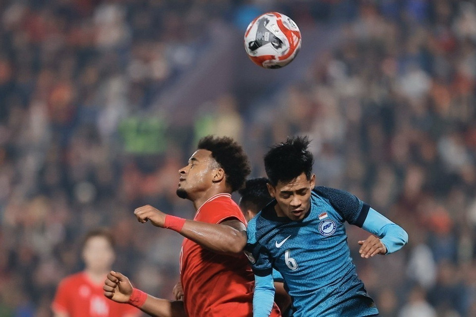 Pha tranh cướp bóng trên không của Xuân Son và hậu vệ Singapore trong trận bán kết lượt về trên sân Việt Trì tối 29/12, với chiến thắng 3-1 cho đội tuyển Việt Nam. (Ảnh: Minh Quyết/TTXVN)