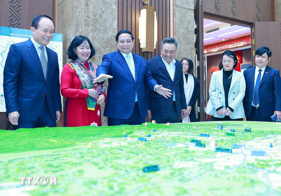 Thủ tướng Phạm Minh Chính xem mô hình Quy hoạch Thủ đô Hà Nội. (Ảnh: Dương Giang/TTXVN)