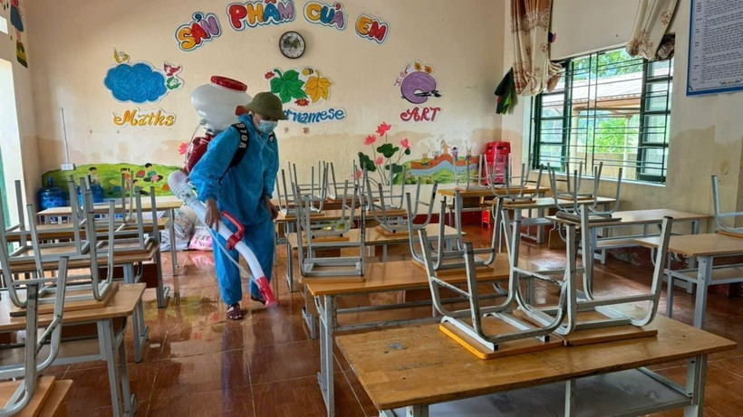 Phun hóa chất tiêu độc khử trùng tại các lớp học của Trường Tiểu học Quang Kim trước ngày học sinh đến trường. (Ảnh: Hương Thu/TTXVN)