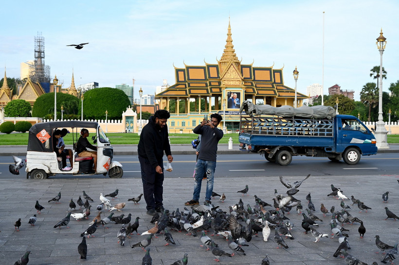 Khách du lịch cho bồ câu ăn tại Phnom Penh, Campuchia. (Ảnh: AFP/TTXVN)