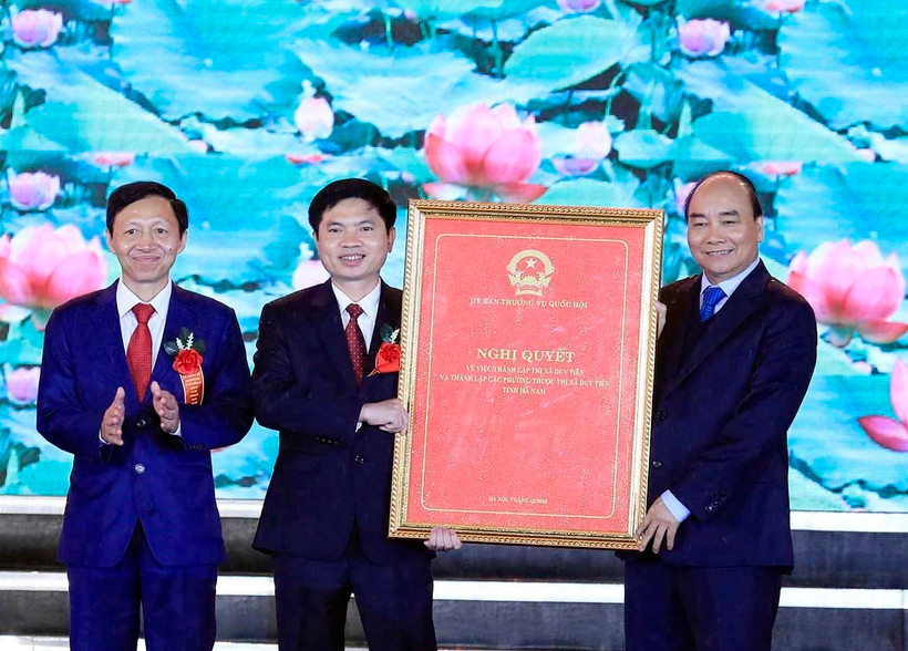 Thủ tướng Nguyễn Xuân Phúc trao Nghị quyết của Ủy ban Thường vụ Quốc hội về thành lập thị xã Duy Tiên, Hà Nam. (Ảnh: Thống Nhất/TTXVN)