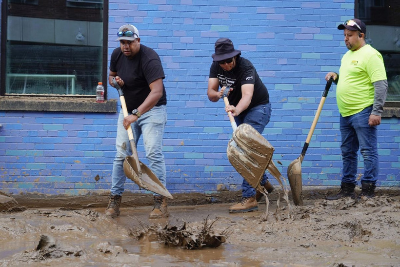 Người dân dọn bùn sau khi bão Helene quét qua ở Asheville, bang North Carolina, Mỹ. (Ảnh: Kyodo/TTXVN)