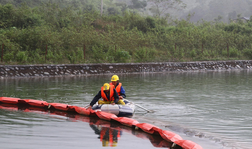 Lực lượng chức năng kiểm tra phao ngăn dầu tại Nhà máy nước sông Đà. (Ảnh: Thanh Hải/TTXVN)