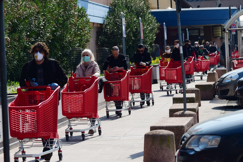 Người dân xếp hàng bên ngoài siêu thị ở Bologna, Italy ngày 21/3/2020, trong bối cảnh dịch COVID-19 lan rộng. (Ảnh: THX/TTXVN)