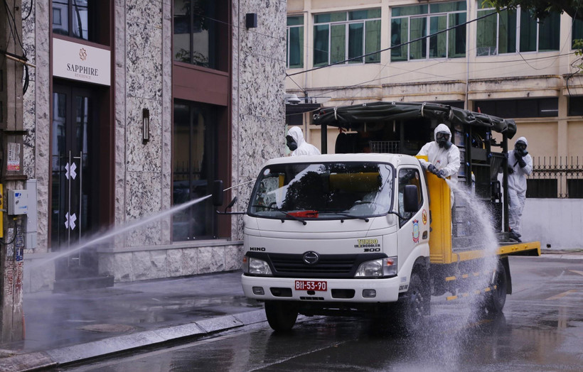 Lực lượng bộ đội hóa học phun hóa chất tiêu tẩy khu vực phố Trúc Bạch, quận Ba Đình, nơi có nhà của bệnh nhân mắc COVID-19. (Ảnh: Dương Giang/TTXVN)