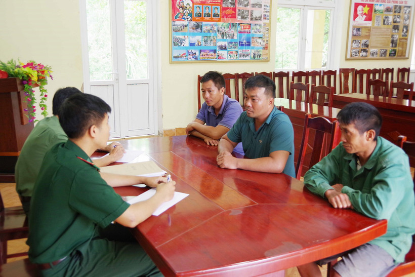Lực lượng chức năng lấy lời khai của các đối tượng tổ chức chở người khác nhập cảnh trái phép. (Ảnh: TTXVN phát)