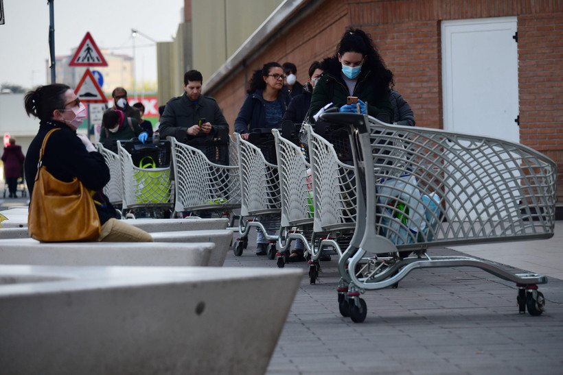 Người dân xếp hàng chờ đợi bên ngoài một siêu thị ở Bologna, Italy ngày 20/3/2020, trong bối cảnh dịch COVID-19 lan rộng. (Ảnh: THX/TTXVN)
