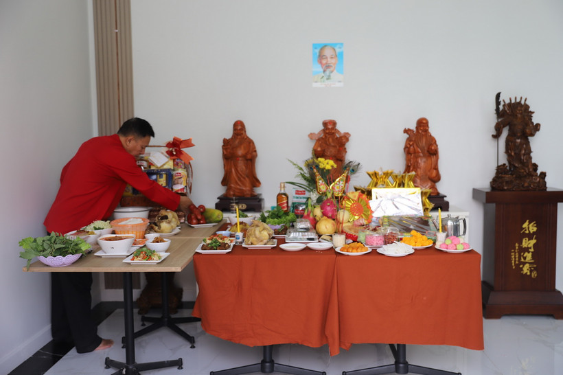 Ông Hòa cẩn thận bày biện bàn lễ cúng ông Công ông Táo. (Ảnh: Đỗ Sinh/TTXVN)
