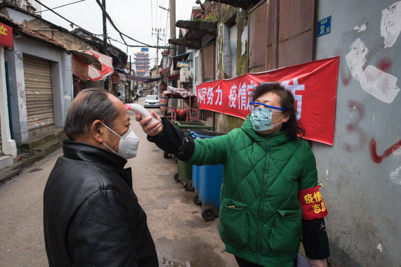 Kiểm tra thân nhiệt của người dân nhằm ngăn chặn sự lây lan của COVID-19 tại Vũ Hán, tỉnh Hồ Bắc, Trung Quốc. (Ảnh: THX/TTXVN)