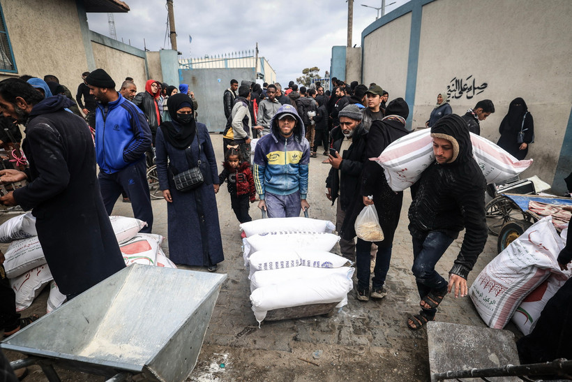 Người tị nạn Palestine nhận lương thực cứu trợ tại thành phố Rafah, Dải Gaza. (Ảnh: AFP/TTXVN)