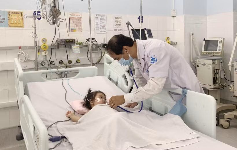 Phó Giáo sư, Tiến sỹ, bác sỹ Phạm Văn Quang, Trưởng Khoa Hồi sức tích cực - chống độc, Bệnh viện Nhi đồng 1 thăm khám cho bệnh nhi. (Ảnh: Đinh Hằng/TTXVN)