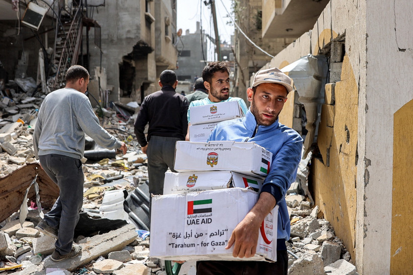 Người dân nhận hàng viện trợ nhân đạo tại Dải Gaza. (Ảnh: AFP/TTXVN)